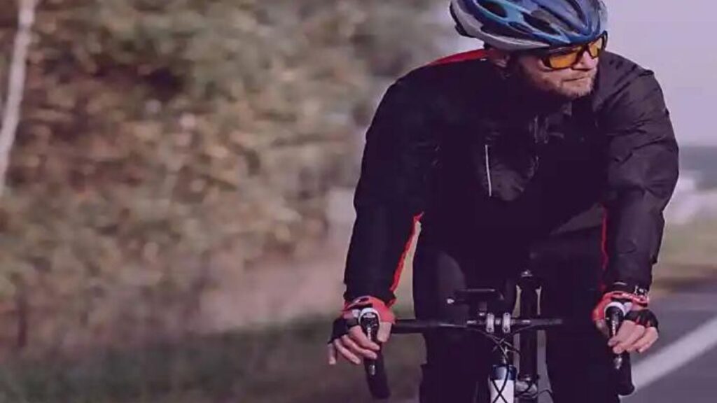 Cortisol Alto! Alerta aos Sinais e Sintomas! A imagem mostra um homem com roupa de ciclismo, pedalando a sua bick, com segurança, usando óculos próprio, luvas e capacete.